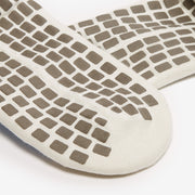 Close-up of a textured sole with square patterns on a white background