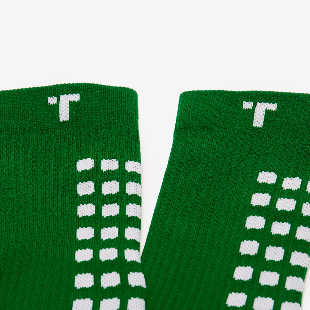Close-up of green socks with white pattern on a white background