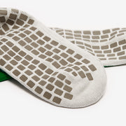 Close-up of a white sock with brown textured sole on a white background