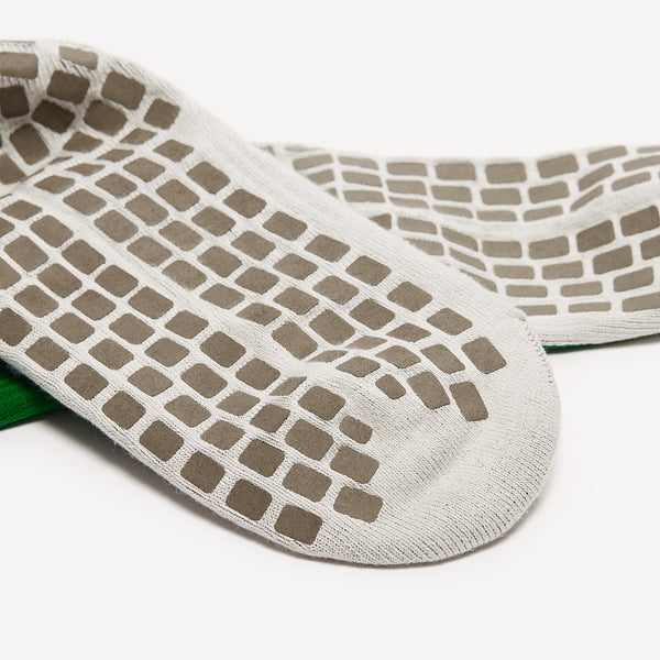 Close-up of a white sock with brown textured sole on a white background