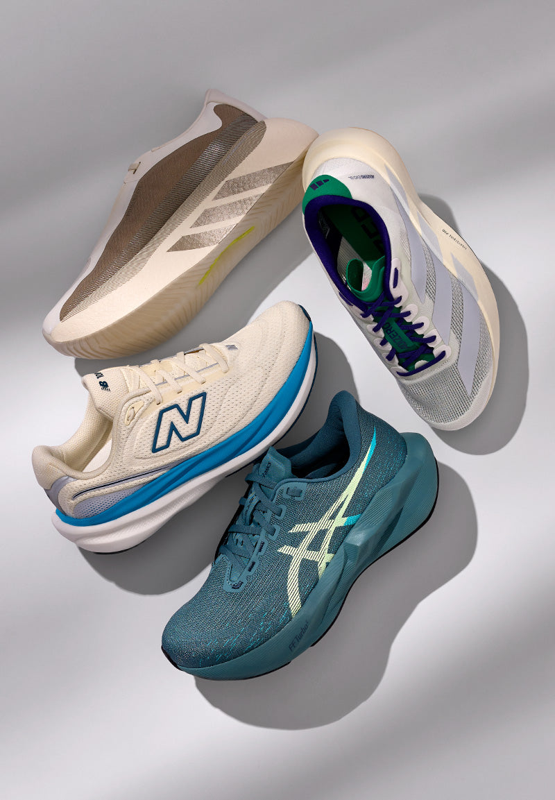 Four athletic sneakers arranged in a fan shape on a light gray background: a cream New Balance shoe, a white and blue New Balance shoe, a teal Asics shoe, and a cream shoe with green and purple accents.