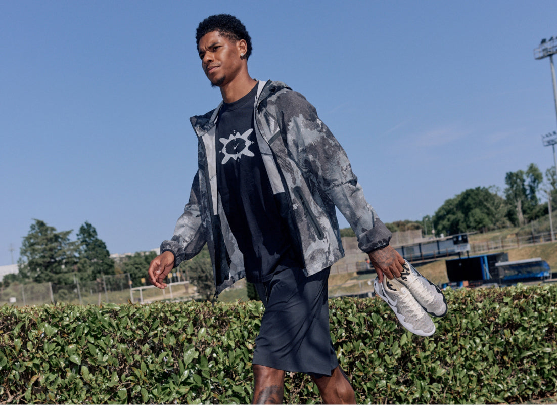someone walking with football boots in hand 