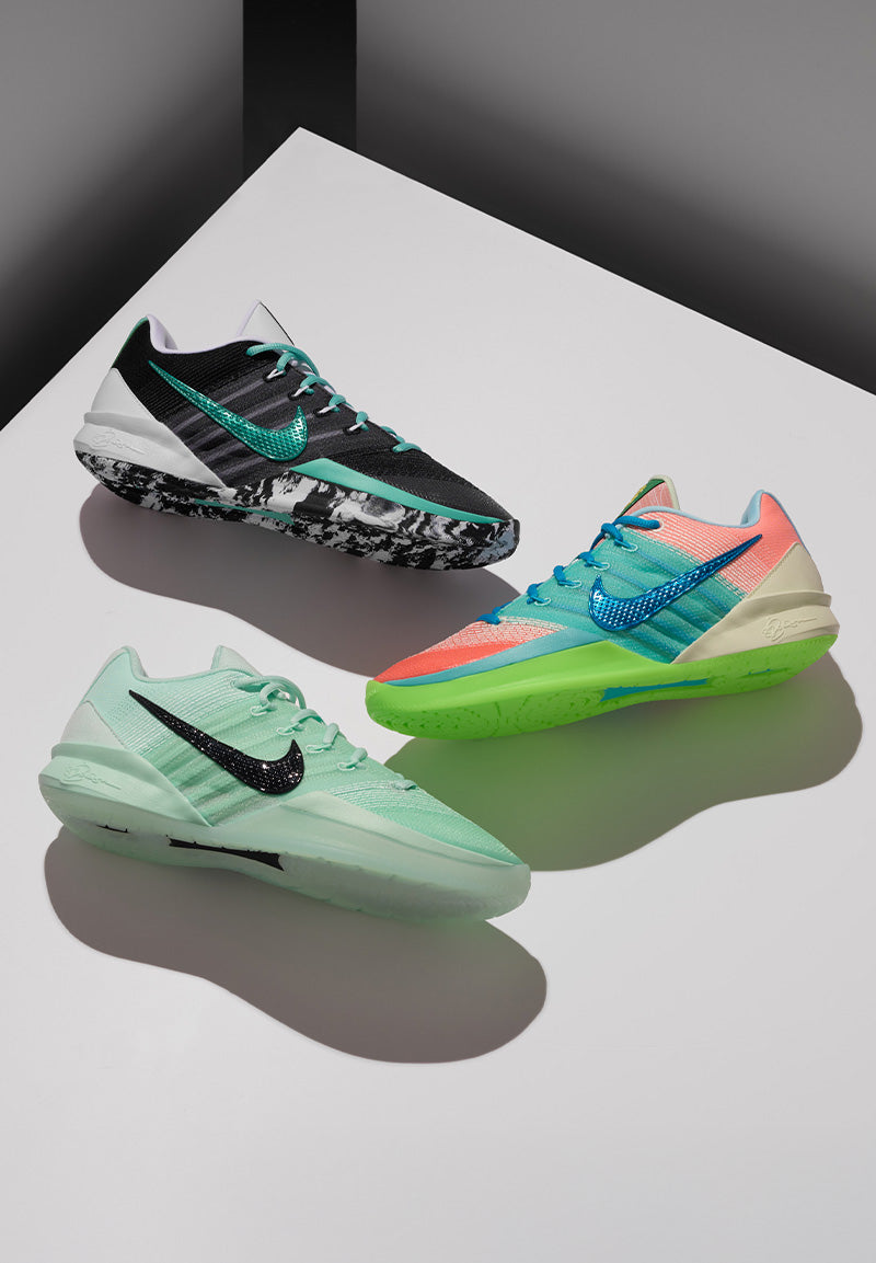 Three colorful running shoes on a reflective surface with a dark background
