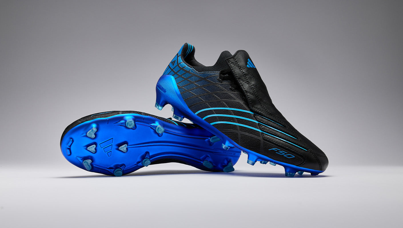Black and blue football boots on a grey background