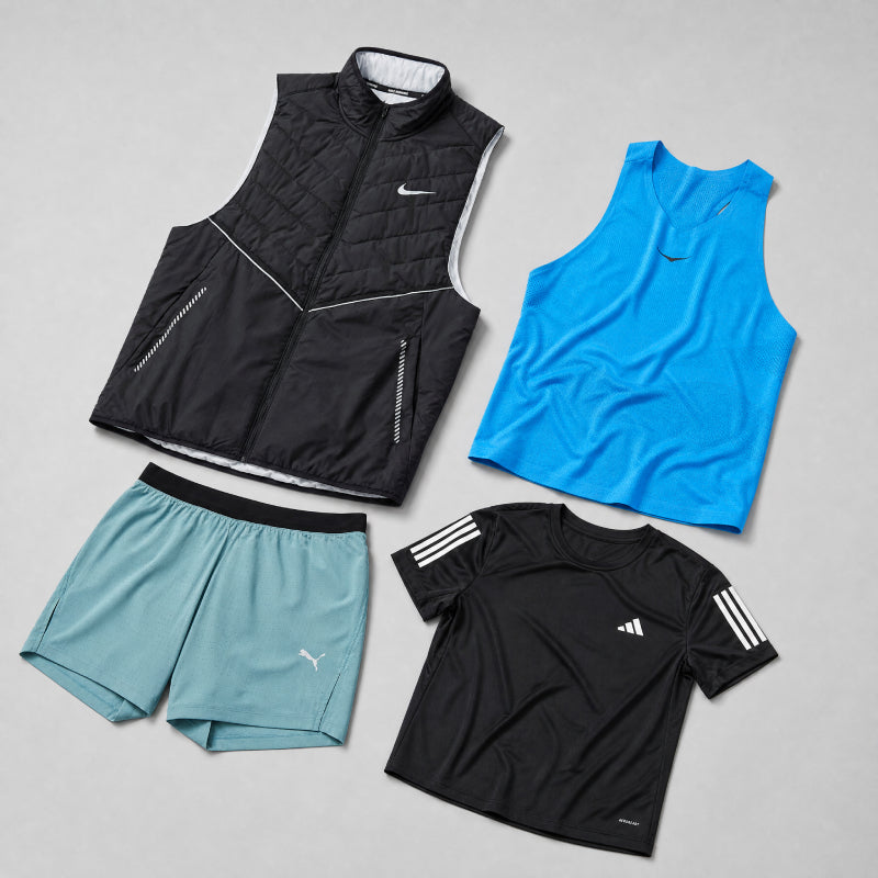 Set of athletic clothing including a black vest, blue tank top, black shorts, and black t-shirt with white stripes on a gray background.
