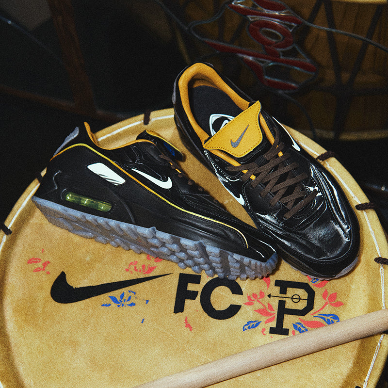 Black and yellow sneakers on a decorative surface with a visible Nike logo.