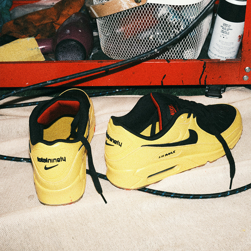 Yellow sneakers with black accents on a carpeted floor.