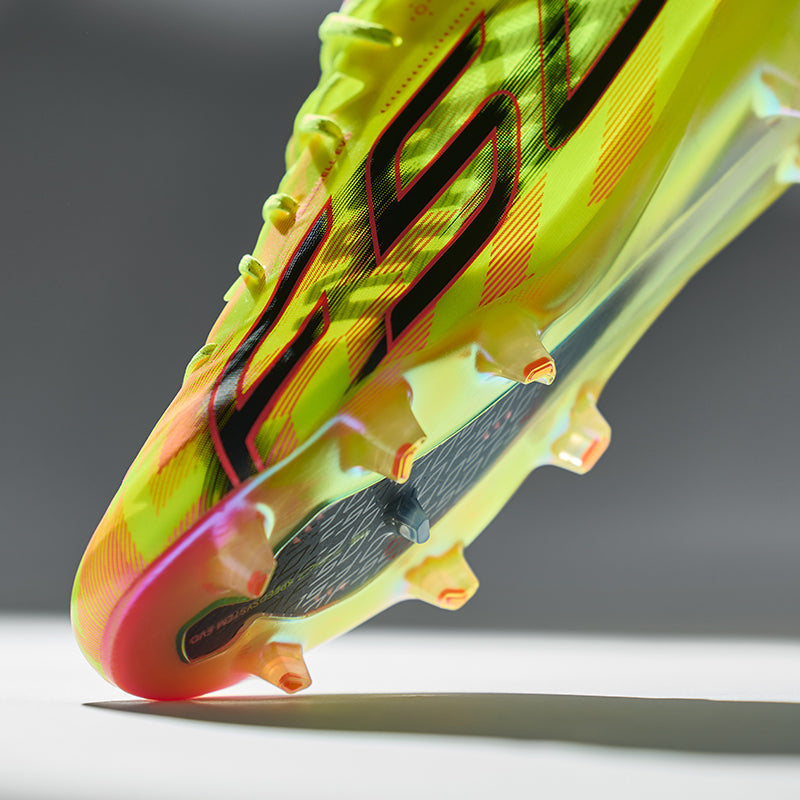 Brightly coloured football boots with brand logo on a grey background